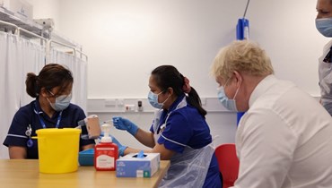 جونسون خلال زيارته مركز تدريب على التطعيم ضد كورونا في مستشفى ميلتون كينز الجامعي شمال لندن (24 ك2 2022، أ ف ب). 