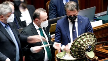 مساعدون برلمانيون يفتحون صندوق الاقتراع في نهاية الجولة الرابعة من التصويت في البرلمان الايطالي في روما (27 ك2 2022، أ ف ب). 