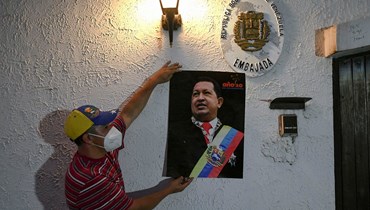 مناصر لنيكولاس مادورو يعلّق صورته على حائط السفارة الفنزويلية في تيغوسيغالبا (أ ف ب).