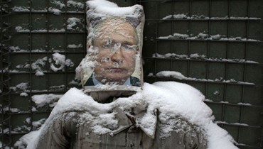 صورة للرئيس الروسي فلادمير بوتين تغمرها الثلوج (أ ف ب).