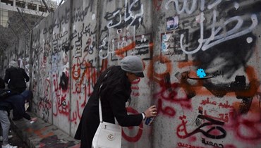 امرأة تكتب على الحائط في بيروت (مارك فيّاض).