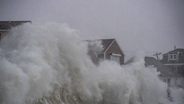 أمواج تتحطم فوق منازل مطلة على المحيط في سيتوات بماساتشوستس خلال عاصفة (29 ك2 2022، أ ف ب). 