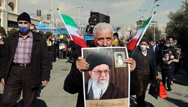 رجل إيراني يحمل صورة خامنئي خلال تجمع في طهران لدعم الحوثيين في اليمن (28 ك2 2022، ا ف ب). 
