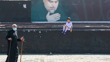 مشهد عام من العراق وتبدو صورة زعيم "التيار الصدري" مقتدى الصدر (أ ف ب).