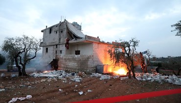 حرق أشياء قرب المنزل الذي قضى فيه القرشي، في أطمة شمال سوريا (3 شباط 2022، أ ف ب).  