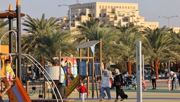 نساء يمشين في ملعب للأطفال في إمارة رأس الخيمة في الإمارات (26 ك2 2022، أ ف ب). 