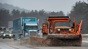 شاحنة تجرف الثلوج والجليد على الطريق السريع 93 خلال عاصفة شتوية في هوكسيت في نيو هامبشاير (4 شباط 2022، أ ف ب). 