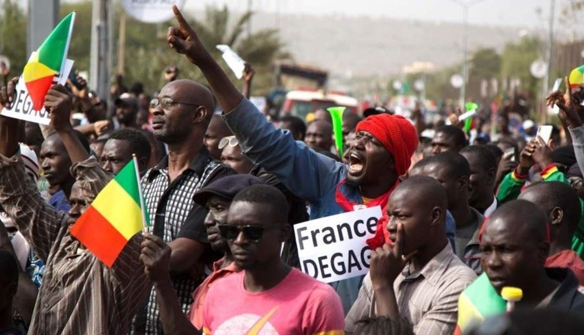 رجل لافتة كُتب عليها "فرنسا أخرجي" خلال احتجاج ضد القوات الفرنسية وقوات الأمم المتحدة في عاصمة مالي باماكو (أ ف ب).