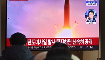 اشخاص يشاهدون على التلفزيون في محطة قطارات في سيول تقريرا إخباريًا عن تجربة صاروخ كوري شمالي (30 ك2 2022، ا ف ب). 