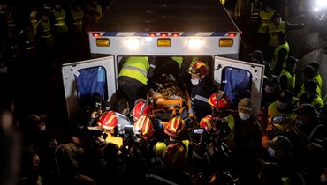 مسعفون ينقلون ريان أورام إلى سيارة إسعاف، بعد اخراجه من البئر في قرية إغران النائية في ريف شفشاون الشمالي (5 شباط 2022، أ ف ب). 