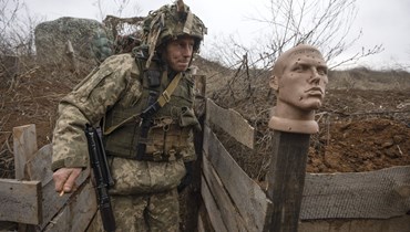 جندي أوكراني يسير في خندق عند الخط الفاصل عن المقاتلين الموالين لروسيا ، في منطقة دونيتسك ، أوكرانيا ، 9 كانون الثاني 2022  (أ ف ب).