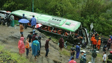 أشخاص يتفقدون الحافلة في بانتول بعد الحادث الذي أوقع 13 قتيلا وعشرات الجرحى (أ ف ب).