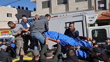 فلسطينيون يحملون جثة مواطن فلسطيني قتلته القوات الإسرائيلية في مدينة نابلس بالضفة الغربية (8 شباط 2022، أ ف ب). 