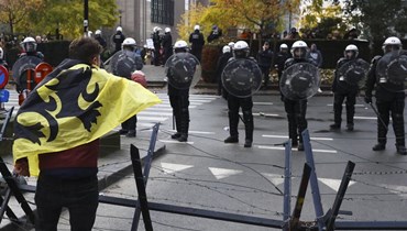 شرطيون خلال مواجهات مع متظاهرين ضد قيود كورونا في بروكسيل (21 ت2 2021، أ ب). 