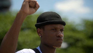 إليسي مبيمبيلي (23 عامًا) صديق كاباغامبي، يرفع قبضته خلال احتجاج على مقتله في ريو دي جانيرو (5 شباط 2022، أ ف ب). 