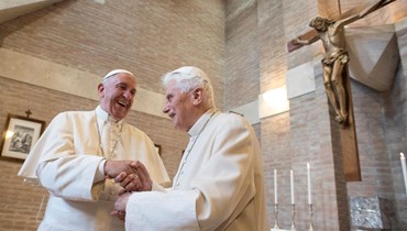 البابا الفخري بنديكتوس السادس عشر (الى اليمين) مصافحا البابا فرنسيس في الفاتيكان (19 ت2 2016، أ ف ب). 