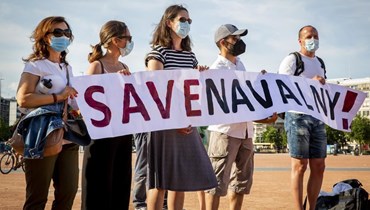 متظاهرون يرفعون لافتة تطالب بإنقاذ نافالني خلال مسيرة في جنيف بسويسرا (15 حزيران 2021، أ ب).
