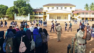 مديرة كلية (الى اليسار) تكلم طالبات وصلن بالحجاب الى الكلية في بلدة كوندابور في منطقة أودوبي بولاية كارناتاكا الهندية (7 شباط 2022، أ ف ب). 