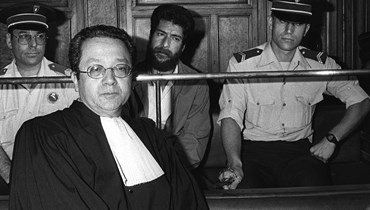 جورج عبد الله (في الوسط الى الاسفل) يجلس بجانب محاميه جاك فرجيس (إلى اليسار) خلال محاكمته في محكمة ليون (3 تموز 1986، ا ف ب). 