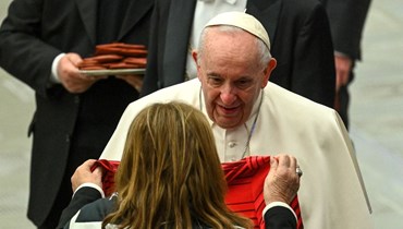 والدة لاعب كرة القدم كريستيانو رونالدو، ماريا دولوريس دوس سانتوس تقدم الى البابا فرنسيس قميص ابنها في نهاية اللقاء الاسبوعي العام في قاعة بول السادس في الفاتيكان (9 شباط 2022، أ ف ب). 