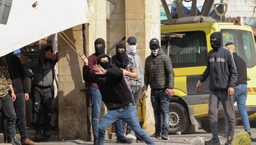 فلسطينيون يرشقون قوات الأمن الإسرائيلية بالحجارة خلال مواجهات في مدينة الخليل بالضفة الغربية (9 شباط 2022، أ ف ب).