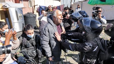  فلسطيني يواجه قوات الأمن الإسرائيلية في حي الشيخ جراح بالقدس الشرقية (13 شباط 2022/ أ ف ب). 