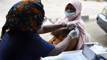 امرأة تتلقى لقاح كورونا في ألاوسا في إيكيجا في نيجيريا (26 ت2 2021، أ ف  ب).