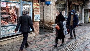 أشخاص يمرون قرب محل جزار في جنوب طهران (20 شباط 2022، أ ف ب). 