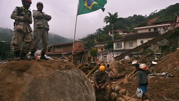 رجال إطفاء خلال مهمة إنقاذ بعد انهيار أرضي ضخم في حي كاكسامبو في بتروبوليس بالبرازيل (19 شباط 2022، ا ف ب). 