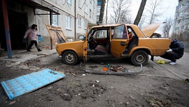 رجل يصلح سيارته القديمة في بلدة كراسنوجوريفكا الصغيرة، في منطقة دونيتسك، بعد قصف الانفصاليين المدعومين من روسيا (أ ف ب).