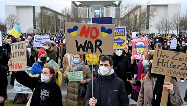 اشخاص يتظاهرون أمام مقر المستشارية في برلين احتجاجا على الغزو الروسي لأوكرانيا (24 شباط 2022، أ ف ب). 