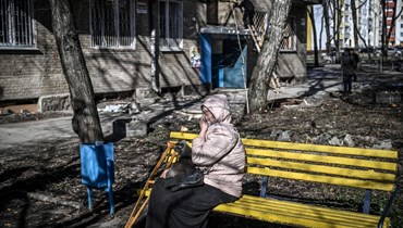 امرأة تبكي وهي تجلس خارج مبنى دمره قصف في مدينة خاركيف شرق أوكرانيا (24 شباط 2022، أ ف ب). 