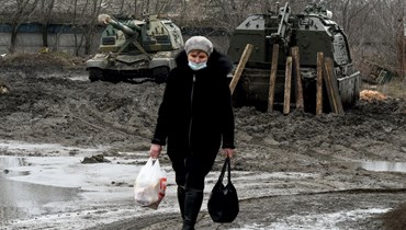 امرأة تحمل مساعدات في أوكرانيا (أ ف ب).