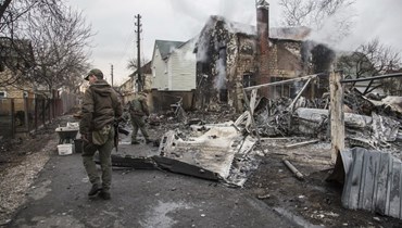 جنود أوكرانيون تجمعوا قرب بقايا طائرة تم اسقاطها في كييف (25 شباط 2022، أ ب). 