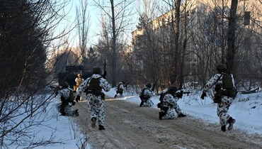 عسكريون أوكرانيون يشاركون في مناورات في مدينة بريبيات الخالية بالقرب من محطة تشيرنوبيل (4 شباط 2022، أ ف ب). 