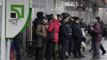 اشخاص انتظروا امام صراف آلي في زابوريزيا في أوكرانيا (25 شباط 2022، أ ب). 