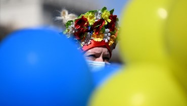 متظاهرة تعتمر إكليل زهور أوكراني تقليدي (فينوك) خلال احتجاج على الغزو الروسي لأوكرانيا، في مدريد (27 شباط 2022 - أ ف ب).