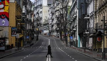مدني يعبر شارعًا مقفرا في وسط مدينة كييف (27 شباط 2022، ا ف ب). 