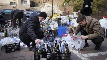 عناصر من الدفاع المدني يجهزون زجاجات حارقة في ساحة في كييف (27 شباط 2022، ا ب). 
