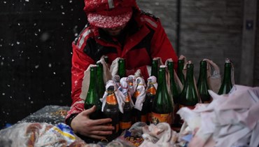 متطوع يوضح كيفية تحضير زجاجات المولوتوف في مصنع الجعة برافدا في لفيف (27 شباط 2022، أ ف ب). 