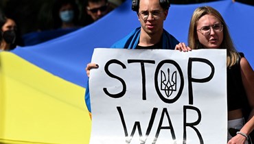 متظاهران يحملان لافتة كُتب عليها "أوقفوا الحرب" أثناء احتجاج على الغزو الروسي لأوكرانيا، أمام السفارة الروسية في كولومبو (28 شباط 2022 - أ ف ب).