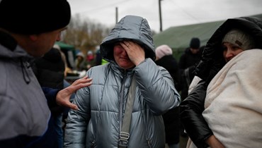 لاجئة أوكرانية تبكي وهي تنتظر وسيلة نقل عند نقطة تفتيش على الحدود بين مولدوفا وأوكرانيا بالقرب من بلدة بالانكا (1 آذار 2022، أ ف ب). 