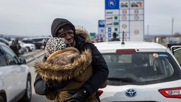 عناق بين لاجئين من أوكرانيا عند المعبر الحدودي في ميديكا بشرق بولندا (1 آذار 2022، أ ف ب). 