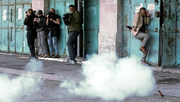 صحافيون خلال تغطيتهم اشتباكات بين متظاهرين فلسطينيين والقوات الإسرائيلية في بلدة الخليل بالضفة الغربية (1 آذار 2022، أ ف ب). 
