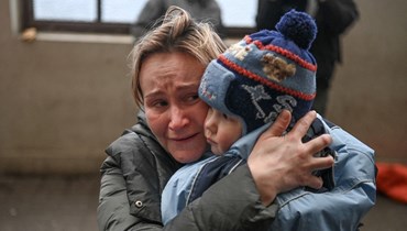 امرأة تحمل طفلها في محطة قطار في لفيف غرب أوكرانيا خلال محاولتها ركوب قطار مجاني إلى بولندا (3 آذار 2022، أ ف ب). 