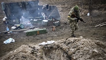 جندي أوكراني يمشي مبتعدا عن معسكر عند خط المواجهة شمال شرق كييف (3 آذار 2022، أ ف ب).