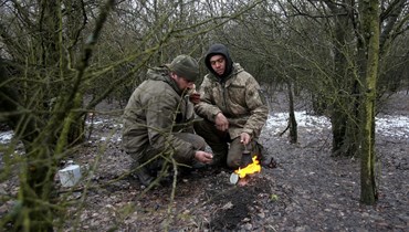 جنديان من القوات العسكرية الأوكرانية خلال استراحة في منطقة لوهانسك (2 آذار 2022- أ ف ب).