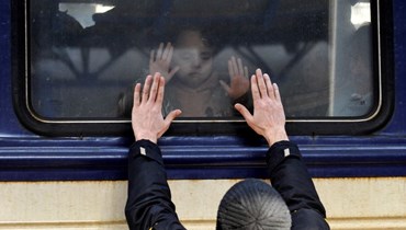 رجل مودعا طفلا في قطار إجلاء في محطة القطارات المركزية في كييف (4 آذار 2022، أ ف ب). 