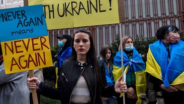 أوكرانيون وقبارصة يشاركون في احتجاج على الغزو العسكري الروسي لأوكرانيا، خارج السفارة الروسية في نيقوسيا (1 آذار 2022، أ ف ب). 