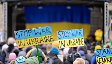 متظاهرون في برلين رفعوا لافتات كتب عليها "أوقفوا الحرب في أوكرانيا" خلال مسيرة لمهرجان الأدب الدولي "من أجل حريتكم وحريتنا! أصوات حول الحرب في أوكرانيا" (6 آذار 2022، ا ف ب). 